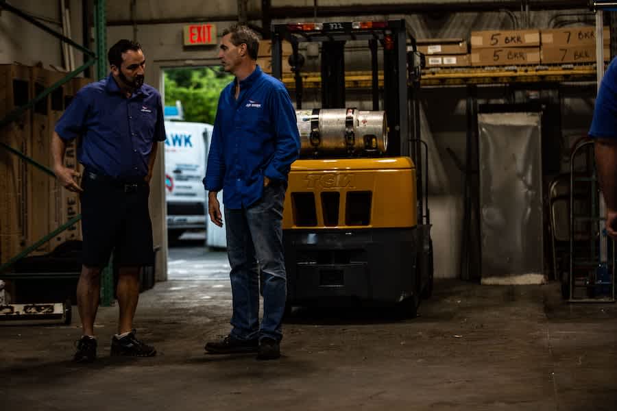 - Housecall Pro two guys talking in a warehouse