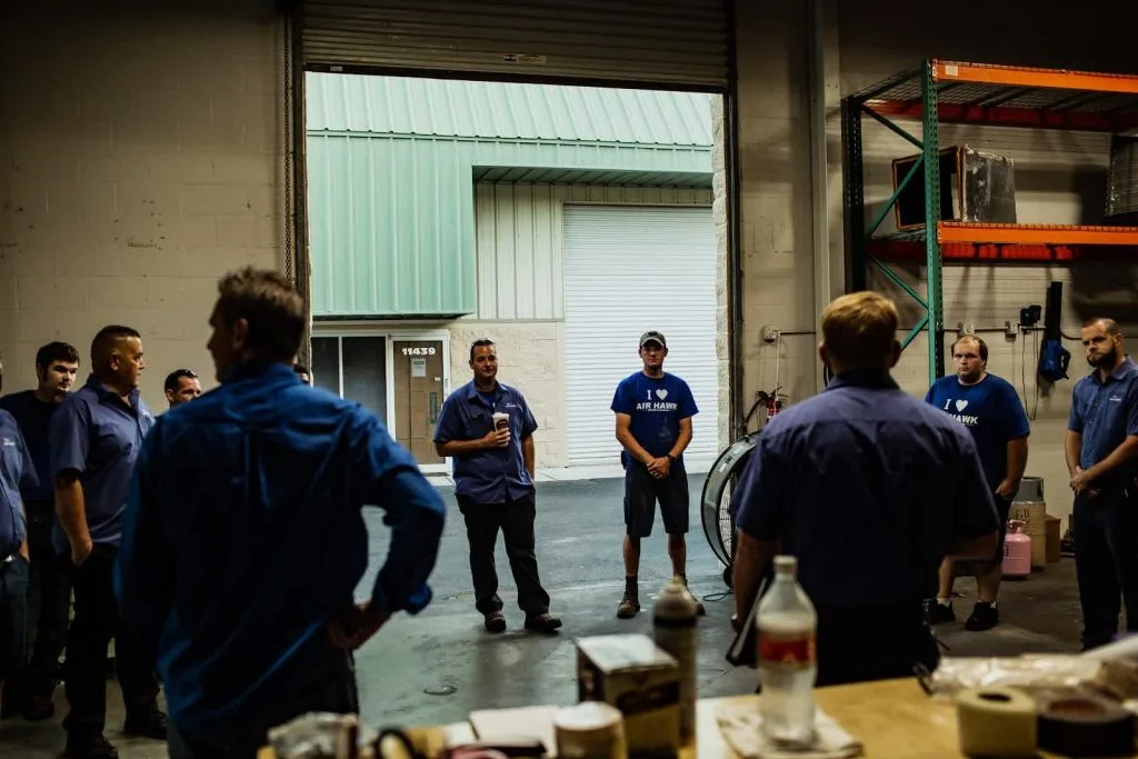 - Housecall Pro HVAC team huddle meeting at warehouse