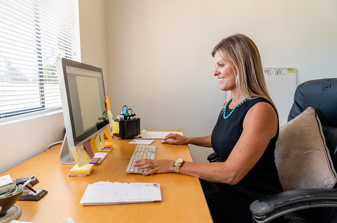 - Housecall Pro Female pro checks time tracking metrics on office desktop