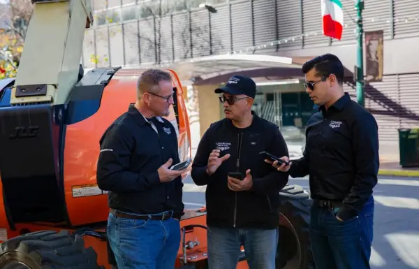 - Housecall Pro HVAC pros meeting in front of orange boom lift