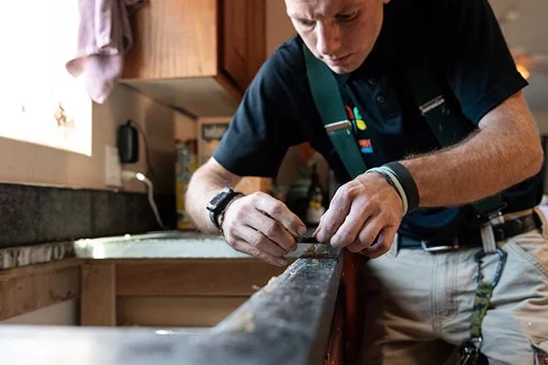 - Housecall Pro handyman working on kitchen counter