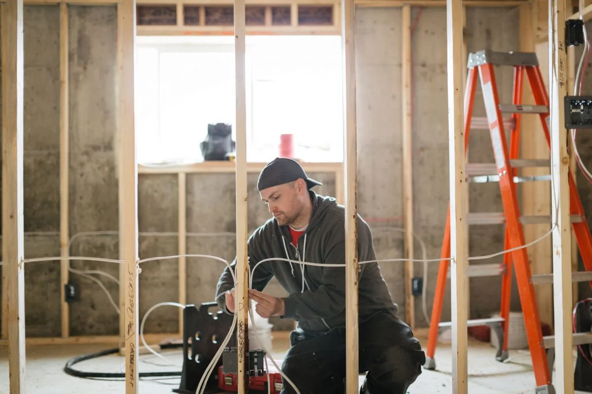 - Housecall Pro Electrician installing wire through wall wood framing
