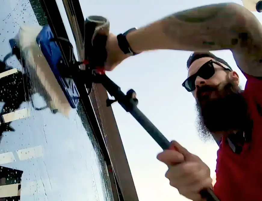 - Housecall Pro Male pro with bead and sunglasses cleaning window