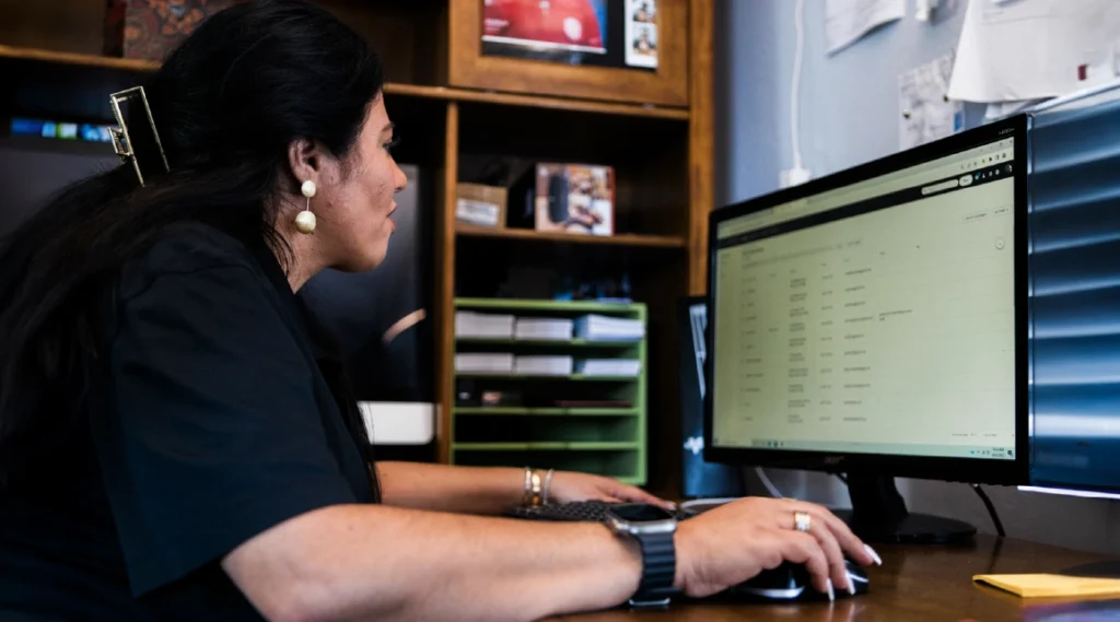 - Housecall Pro Woman cleaning business owner views desktop screen in her office