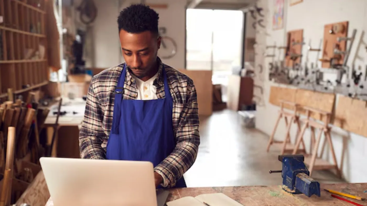 - Housecall Pro pro using laptop to calculate overhead costs