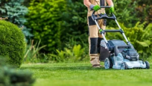 pro gardener trimming the lawn using electric mower