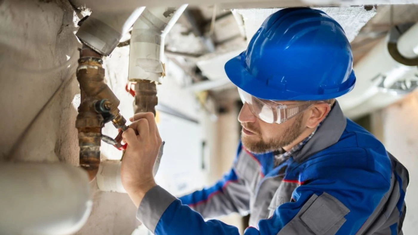pro inspecting a plumbing valve for maintenance or repair