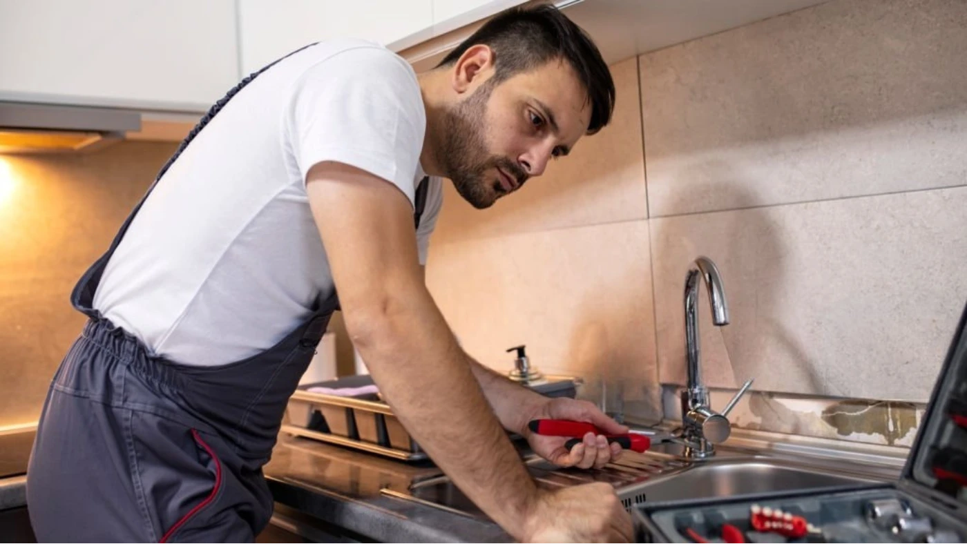 pro plumber fixing kitchen sink