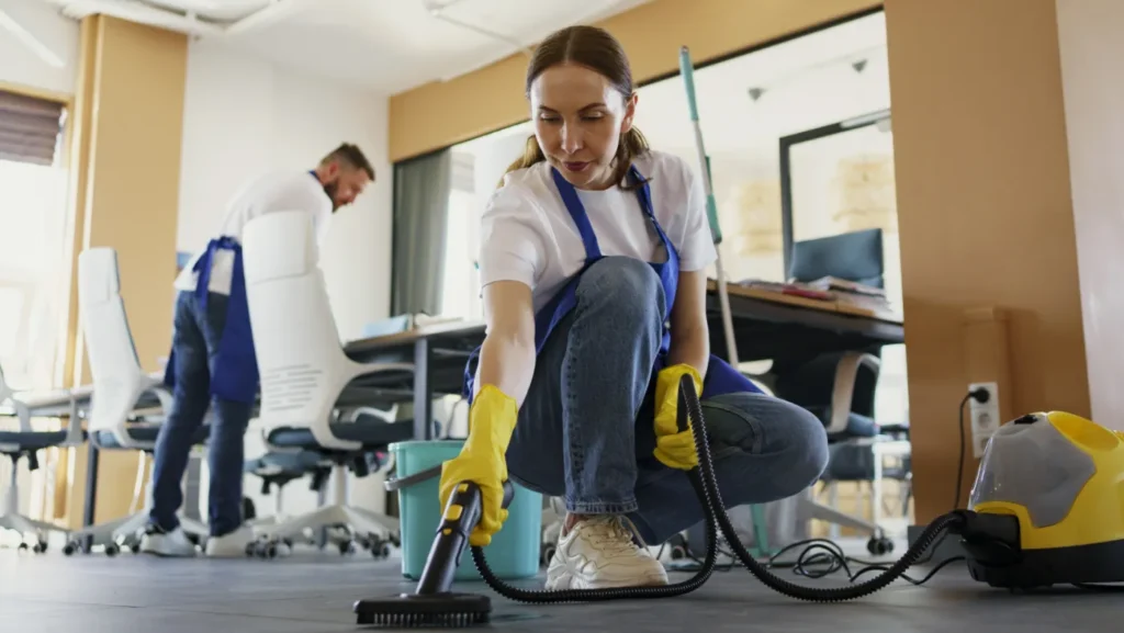 Professional cleaning service person using vacuum cleaner in office