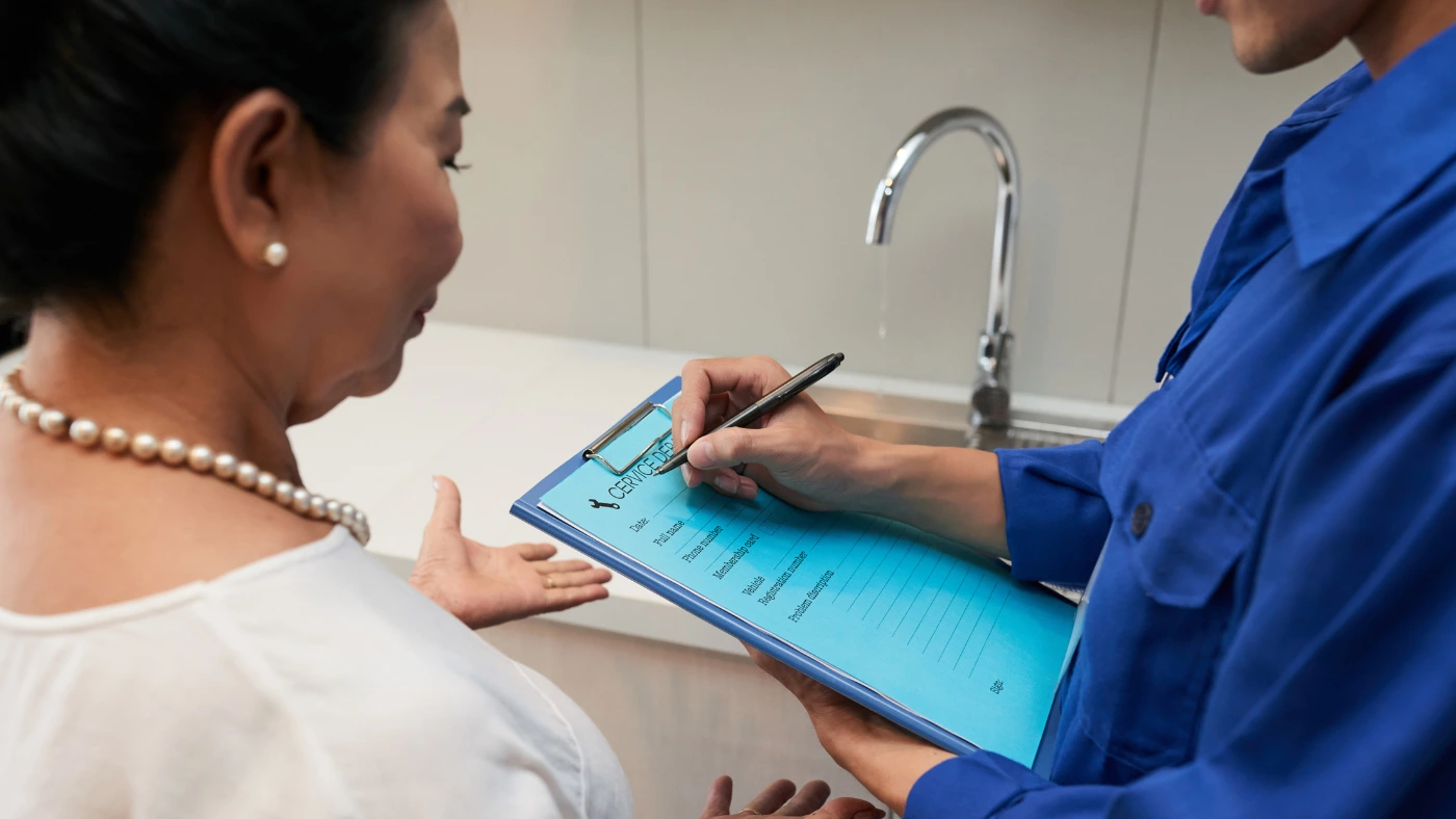 Cleaning service professional reviewing a service checklist with a homeowner during an in-home visit.