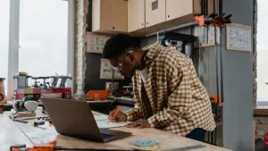 HVAC contractor working on a website plan at a workbench with a laptop in a workshop