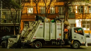 Loaded junk removal truck parked on a city street, illustrating the type of hauling business a strong slogan helps promote.